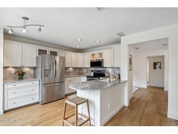 Bright kitchen boasts stainless steel appliances, marble countertops, and light wood flooring at 4430 E Creosote Dr, Cave Creek, AZ 85331