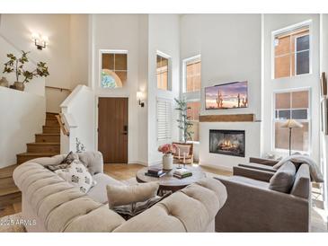 Bright living room features soaring ceilings, a cozy fireplace, and elegant furnishings at 4430 E Creosote Dr, Cave Creek, AZ 85331