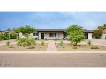 Charming single-story home featuring a well-manicured front yard with desert landscaping and brick pathway leading to the front door at 5441 E Wethersfield Rd, Scottsdale, AZ 85254