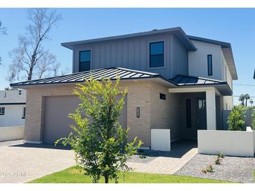 Modern two-story home featuring a brick facade, gray siding, and a well-manicured front yard at 5537 E Earll Dr, Phoenix, AZ 85018