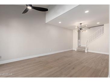 Spacious living room with high ceilings, modern fan, wood floors, and staircase at 6004 N 79Th St, Scottsdale, AZ 85250
