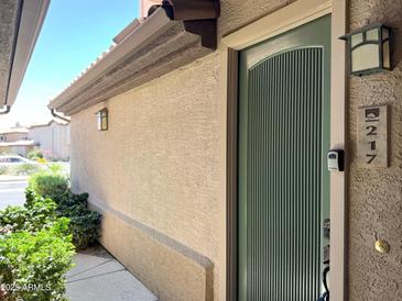 Close up of a green front door with address number in a stucco building at 6535 E Superstition Springs Blvd # 217, Mesa, AZ 85206