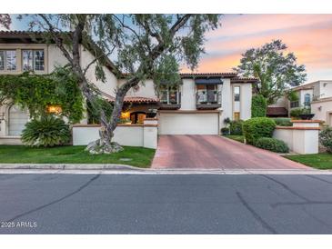 Attractive two-story home with a terracotta roof, lush landscaping, private balconies and a red brick driveway at 6701 N Scottsdale Rd # 26, Scottsdale, AZ 85250