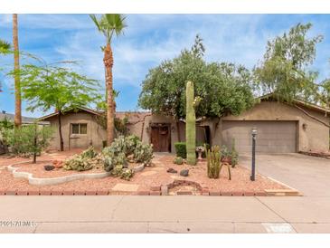 Charming desert landscaping enhances this single-story home with a two-car garage and red rock accents at 7210 N 17Th Ave, Phoenix, AZ 85021