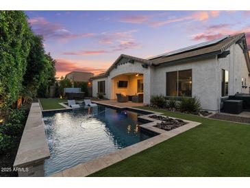 Inviting backyard with a sparkling pool, hot tub and outdoor seating area perfect for relaxing and entertaining at 883 E Hampton Ln, Gilbert, AZ 85295