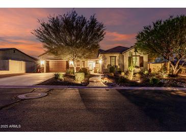 Charming home with a well-manicured front yard and cozy curb appeal at twilight at 12725 W Forest Pleasant Pl, Peoria, AZ 85383