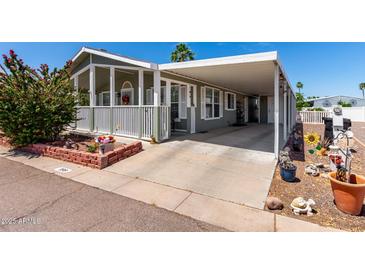 Charming home featuring a covered carport, front porch and beautiful landscaping at 201 S Greenfiled Rd -- # 199, Mesa, AZ 85206