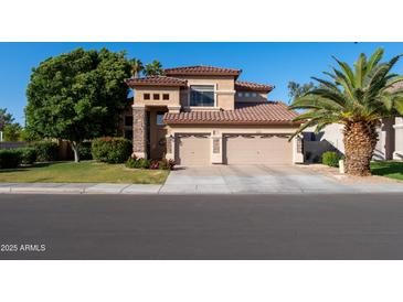 Inviting two-story home featuring a two-car garage, manicured lawn, and desert landscaping at 2224 W Olive Way, Chandler, AZ 85248