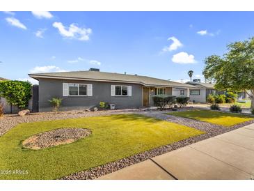 Well-maintained single-story home featuring xeriscaped front yard with lush, green, artificial lawn at 2715 E Edgemont Ave, Phoenix, AZ 85008