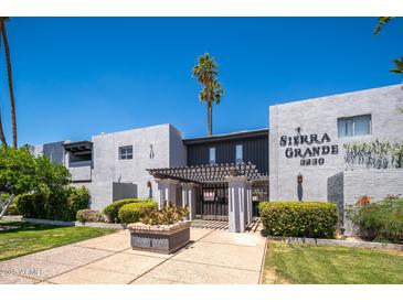 Sierra Grande building exterior with palm trees and manicured landscaping on a sunny day at 3230 E Pinchot Ave # 32, Phoenix, AZ 85018