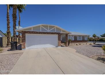 Charming home featuring a two-car garage, desert landscaping and a brick exterior at 3362 E Carol Ave, Mesa, AZ 85204