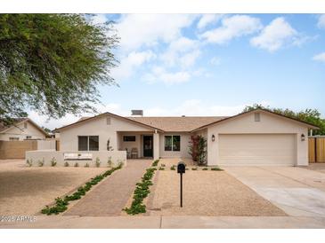Charming single-story home with a manicured front yard and attached garage, perfect for suburban living at 4948 E Evans Dr, Scottsdale, AZ 85254