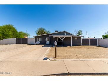 Charming single-story home featuring a covered porch, desert landscaping and a long driveway at 511 E Purdue Ave, Phoenix, AZ 85020
