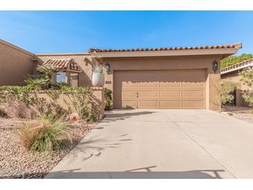 Tan home exterior with a red tile roof, complemented by desert landscaping and a spacious two-car garage at 10626 N 8Th St, Phoenix, AZ 85020