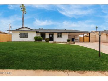 Charming single-story home with well-manicured lawn and carport in a sunny neighborhood at 1515 N Saguaro Dr, Tempe, AZ 85288