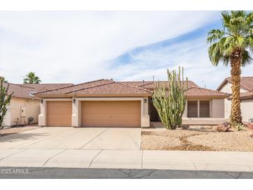 Charming single-story home boasts a well-maintained landscape, tile roof, and a spacious three-car garage at 4020 W Menadota Dr, Glendale, AZ 85308