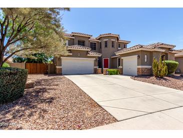 Stunning two-story home featuring a red door, three-car garage and drought tolerant landscaping at 4123 S Wayne Pl, Chandler, AZ 85249