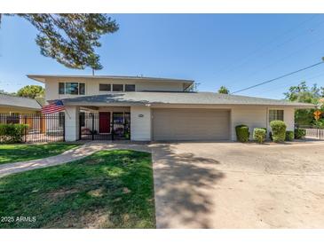 Two-story home features a red door, gray garage door, brick pathway, and manicured lawn at 8464 N 7Th Ave, Phoenix, AZ 85021