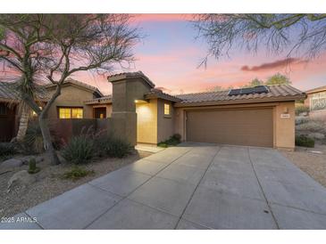 Charming home exterior with a private drive and well-maintained desert landscaping under a vivid sunset sky at 11400 E Helm Dr, Scottsdale, AZ 85255