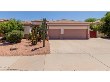 Charming single-story home featuring a two-car garage and desert landscaping with mature cactus and shrubs at 115 E Spur Ave, Gilbert, AZ 85296