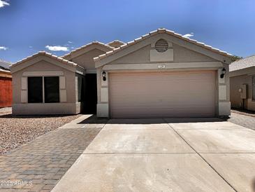 Charming single-story home featuring a two-car garage, low maintenance desert landscaping, and a welcoming facade at 1339 W Mesquite Ave, Apache Junction, AZ 85120