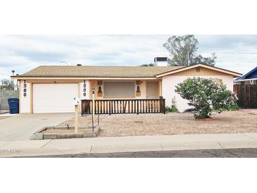 Charming single-story home featuring desert landscaping, a welcoming front porch, and an attached garage at 1586 S Lawther Dr, Apache Junction, AZ 85120