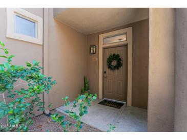 Inviting home entrance with a wreath on the door and desert plants on the side at 20100 N 78Th Pl # 1023, Scottsdale, AZ 85255