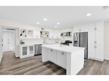 Bright modern kitchen with white cabinets, stainless steel appliances, and a large center island at 301 N 87Th St, Mesa, AZ 85207