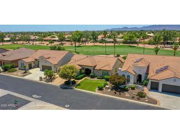 Beautiful single-Gathering home with lush landscaping, desert accents, and a red tile roof overlooking the golf course at 3702 N 160Th Ave, Goodyear, AZ 85395