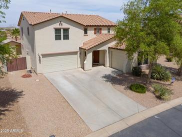 Stunning two-story home featuring a spacious driveway, three-car garage, and desert landscaping at 40232 W Marion May Ln, Maricopa, AZ 85138