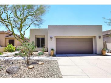 Inviting home featuring a two-car garage, neutral stucco, and desert landscaping at 6939 E Bramble Berry Ln, Scottsdale, AZ 85266