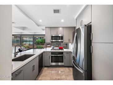 Modern kitchen with gray cabinets, stainless steel appliances, and quartz countertops, offering a sleek design at 7141 E Rancho Vista Dr # 6007, Scottsdale, AZ 85251