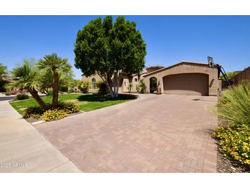 Stunning home with a brick driveway, mature trees, and desert landscaping at 9842 E Celtic Dr, Scottsdale, AZ 85260