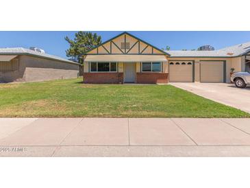 Charming single Gathering home featuring a well-maintained front yard and a two-car garage at 10201 N 97Th Ave # B, Peoria, AZ 85345