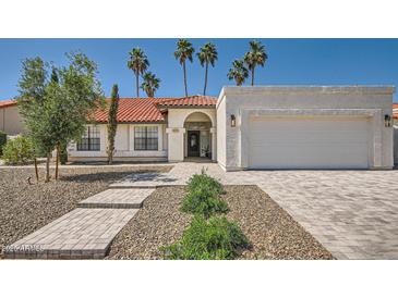 Charming single-story home featuring a red tile roof, landscaped yard, and a two-car garage at 10522 E Bella Vista Dr, Scottsdale, AZ 85258