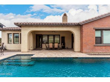 Relaxing pool view featuring covered outdoor dining and seating area, blending indoor and outdoor living spaces at 20532 W Summit Pl, Buckeye, AZ 85396