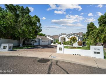 Beautiful single-story home with mature trees and a well-manicured lawn in a suburban neighborhood at 210 E Cactus Wren Dr, Phoenix, AZ 85020