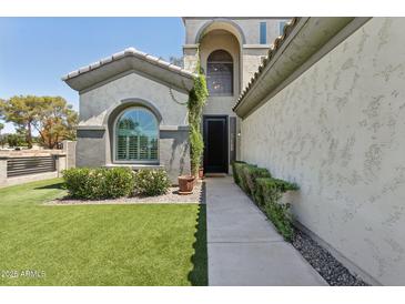 Welcoming home entrance featuring manicured landscaping and a well-lit pathway to the front door at 3202 E Orange Dr, Phoenix, AZ 85018