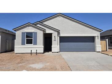 Charming single-story home featuring a gray garage door and inviting entrance with blue window shutters at 35556 N Common Ct, San Tan Valley, AZ 85140