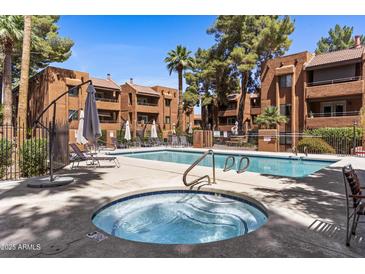 Inviting community pool and spa area with lounge chairs and shade umbrellas at 4704 E Paradise Village N Pkwy # 236, Phoenix, AZ 85032