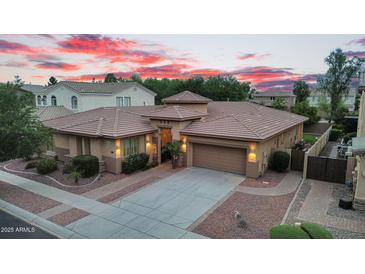 Beautiful single-story home with a well-manicured yard and a tile roof against a colorful twilight sky at 4756 E Ironhorse Rd, Gilbert, AZ 85297