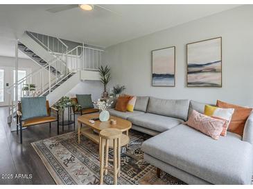 Cozy living room with modern decor, staircase, and plush sectional sofa at 6945 E Osborn Rd # E, Scottsdale, AZ 85251