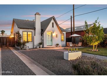 Charming white brick home featuring a lovely front patio, beautiful landscaping, and a light blue front door at 1111 E Coronado Rd, Phoenix, AZ 85006