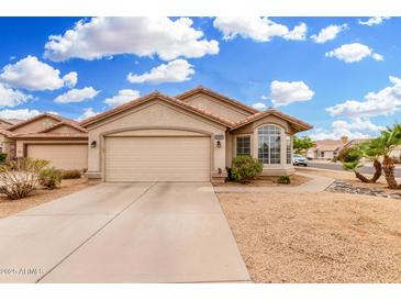 Charming single-story home featuring a two-car garage, desert landscaping, and a tile roof at 13137 W Wilshire Dr, Goodyear, AZ 85395
