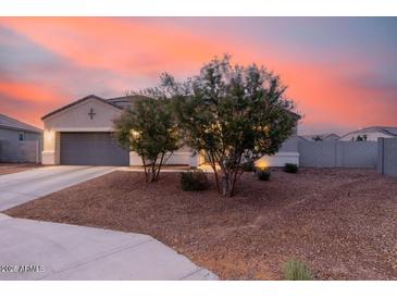 Inviting home exterior at dusk, featuring low-maintenance landscaping and a two-car garage at 203 S 190Th Ave, Buckeye, AZ 85326