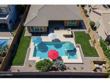 Gorgeous aerial view of a backyard featuring a sparkling pool, spa, lush landscaping, and ample patio space at 4266 E Blue Sage Ct, Gilbert, AZ 85297