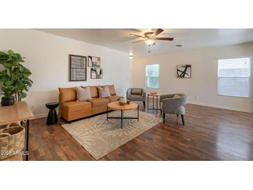 Bright living room featuring a modern tan leather sofa, ceiling fan, and stylish decor at 4642 E Sierrita Rd, San Tan Valley, AZ 85143