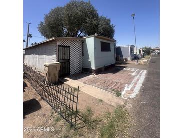 Single-story mobile home featuring brick trim and desert landscaping at 6439 W Myrtle Ave # 49, Glendale, AZ 85301