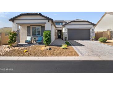 Charming single-story home boasts a desert landscape, stone accents, and a spacious two-car garage at 8040 E Jaeger St, Mesa, AZ 85207
