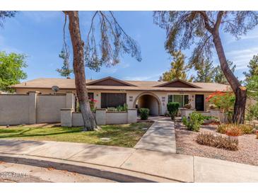 Charming townhome featuring lovely landscaping and a welcoming walkway to the front entrance at 1047 W Laguna Dr, Tempe, AZ 85282